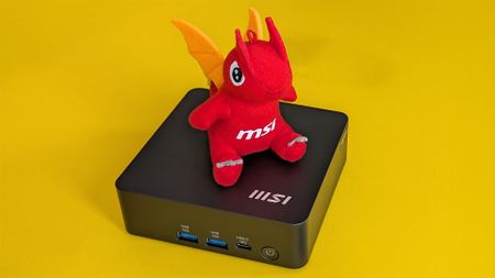 MSI Cubi NUC AI-1UMG mini PC on yellow background with red MSI dragon mascot sitting on top
