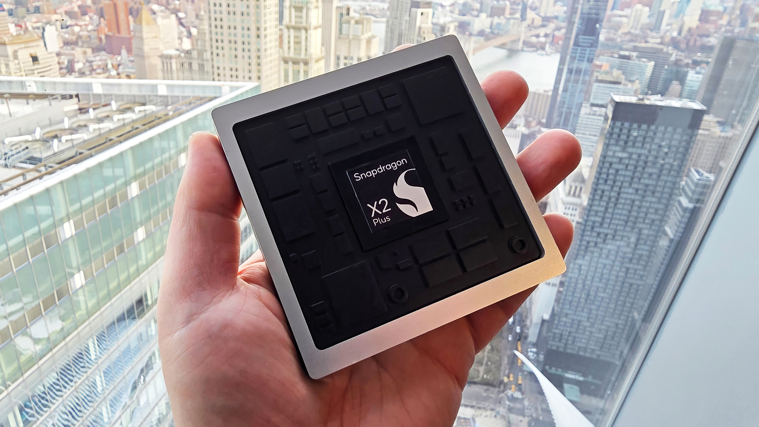 Qualcomm's new X2 Plus processor marketing prop being held by a window.