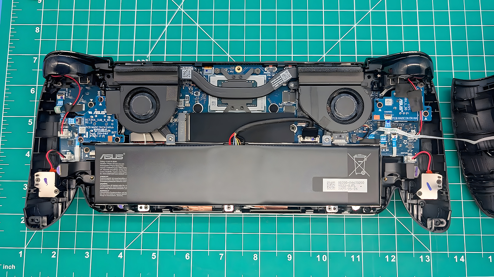 The ROG Xbox Ally X opened with battery, fans, and other components showing.