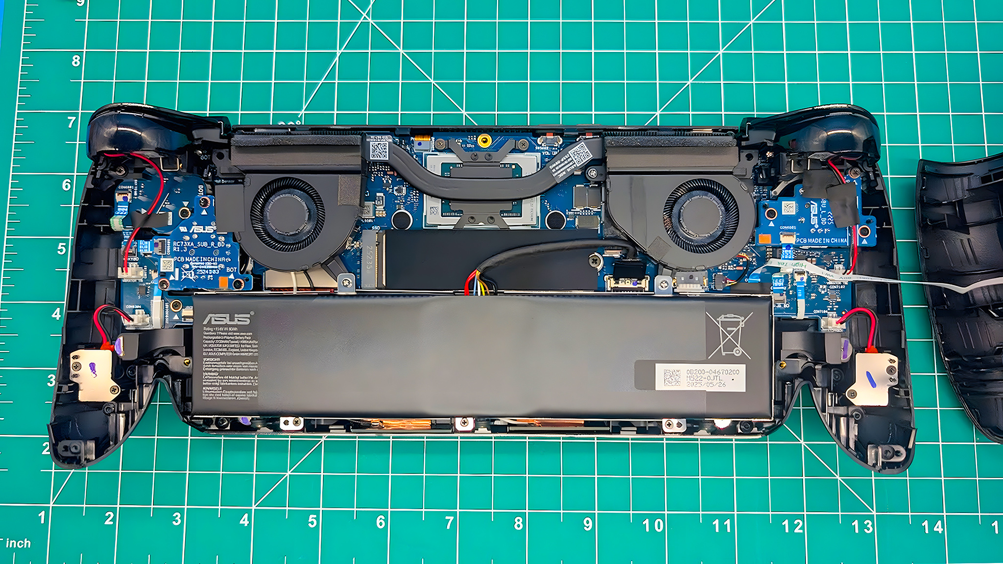 The ROG Xbox Ally X opened with battery, fans, and other components showing.